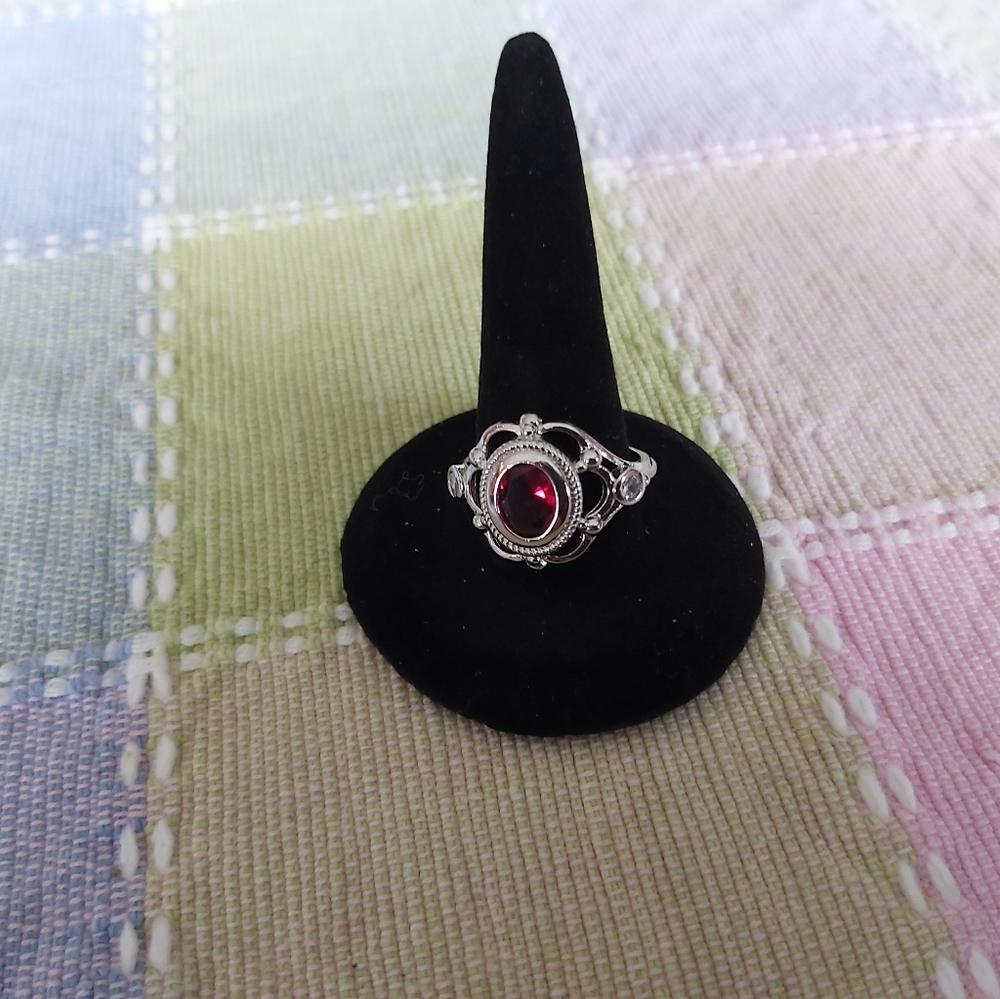Silver tone, ruby colored stone ornate ring